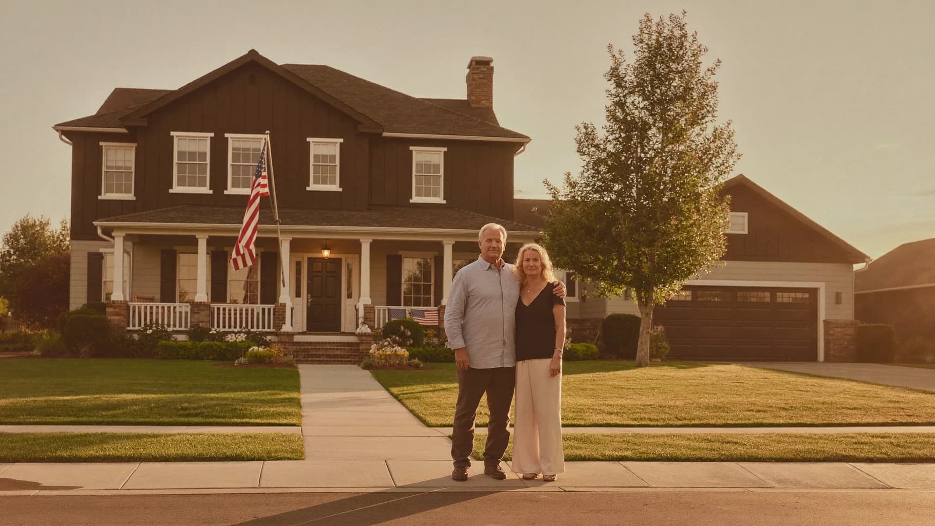 American homeowners standing in front of the home they kept